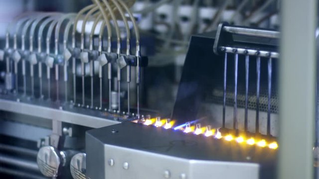 Pharmaceutical vials production line at medical factory. Close up of medical ampules production at pharmaceutical plant. Medical ampoules manufacturing process. Pharmaceutical industry