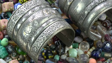 Ancient indian bracelet armlet rotating on old beads background