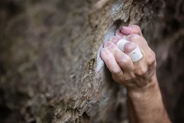 Fotobehang Closeup of rock climber's hand gripping hold © Andrey Bandurenko