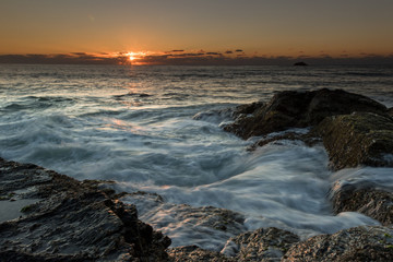 sunrise over a rock ledge with moving water