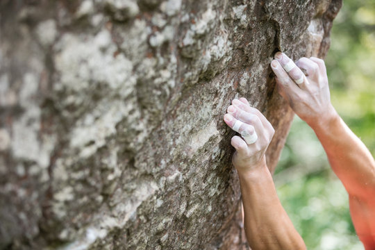 Rock climber's hands gripping small holds