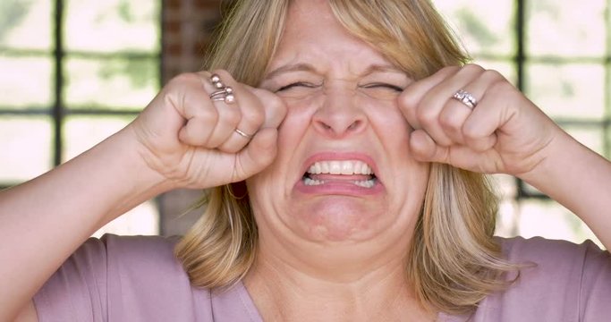 Unhappy woman crying and wiping her face with her hands - waa waah