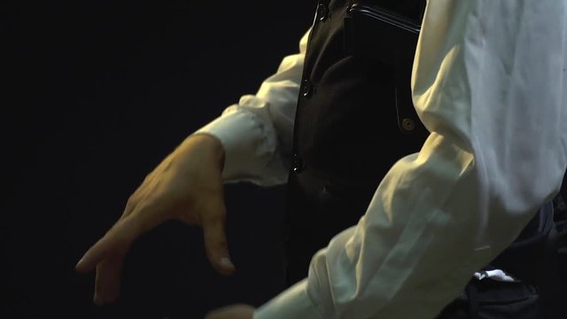 Gangster calculates dollars, takes out a pistol from his holster and looks into the camera