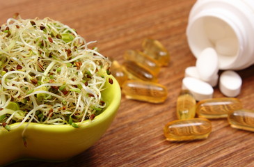 Alfalfa and radish sprouts with tablets supplements, choice between healthy eating and pills