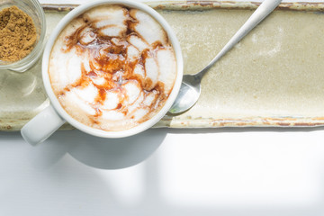 Closeup top view hot coffee latte on table with light of sun at morning, happy feelling