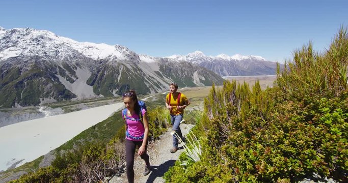 Hiking travel people in New Zealand. Couple people walking on Sealy Tarns hike trail route in Mount Cook national park landscape, a famous tourist attraction. RED EPIC SLOW MOTION.