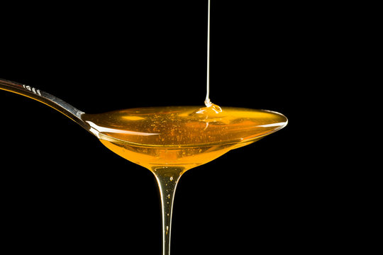Spoonful of honey on the black background