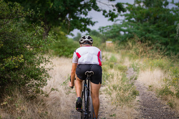 Biycle rider on cyclocross bike training outdoor on gravel  country road 