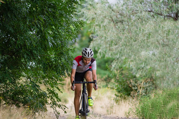 Biycle rider on cyclocross bike training outdoor on gravel  country road 