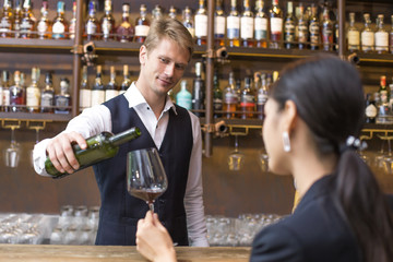 Bartender serving Wine to Customer at counter, Bartender enjoy to serving Wine for Customer, People Lifestyle Concept.