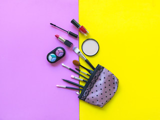 Cosmetics and fashion background with make up artist objects: lipstick, eye shadows, mascara ,eyeliner, concealer, nail polish.  Pink and yellow colorfull Background.  Lifestyle Concept