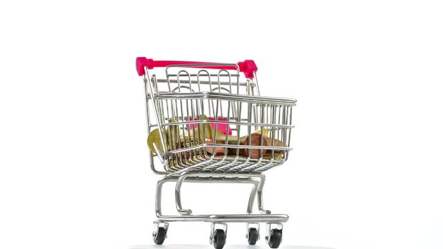 Shopping cart with coins falling , turning. Concept of success in business