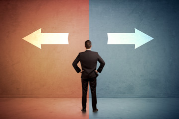 Salesman standing in front of two arrows on blue and red background concept
