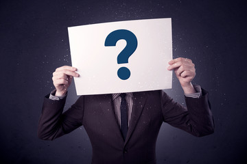 Businessman holding paper with question marks