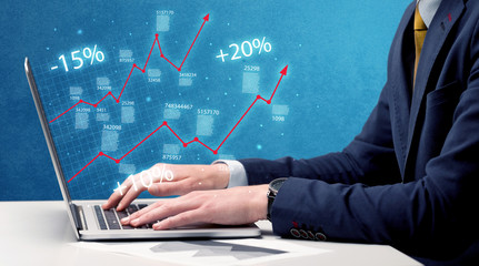 Salesman working on graph with laptop