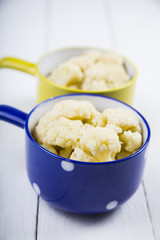 Boiled cauliflower in multi-colored bowls