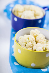 Boiled cauliflower in multi-colored bowls