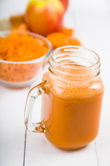 Apple-carrot juice on a wooden table.