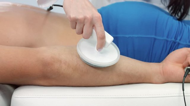 Electrotherapeutic procedure on the man's forearm