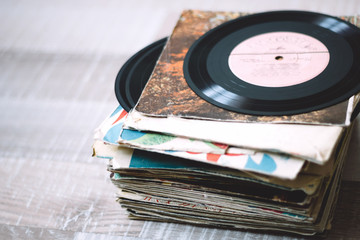 a stack of old vinyl records on a wooden floor