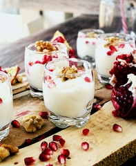 yogurt dessert with walnuts and pomegranate selective focus