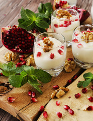 yogurt dessert with walnuts and pomegranate selective focus