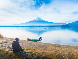 silhouette asia couple traveler 30s to 40s sit and pull boat on ground at side of lake kawaguchi on morning time with fuji mountain background