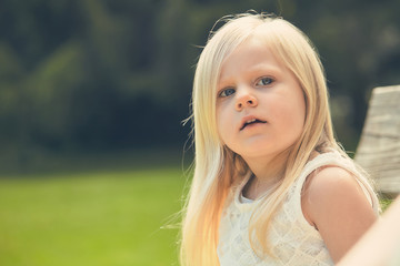 Portrait of serious little girl in white dress