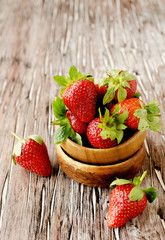 Fresh strawberries in a wooden bowl, selective focus