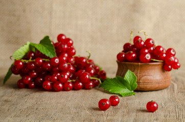 Red currant in wooden plate on the table