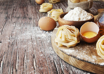 Uncooked pasta with flour on the table, selective focus