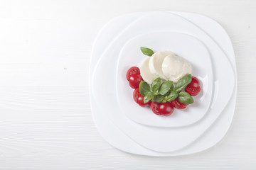 Mozzarella with tomato and green basil.