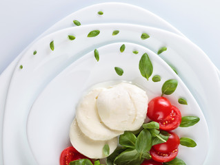Mozzarella with tomato and green basil.