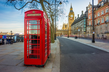 London, England - Traditional Old British red telephone box at Victoria Embankment with Big Ben at...