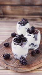 yogurt cup with blackberry on wooden table