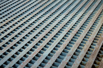 Vintage grille sewage pipe with rust for cover the drain on concrete road or street.