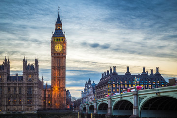 London, England - The famous Big Ben and Houses of Parliament with iconic red double decker buses on Westminster Bridge at dusk - obrazy, fototapety, plakaty