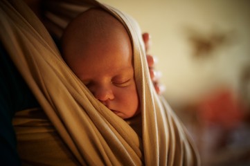Infant sleeping in a sling