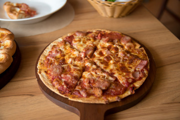 Pizza is delicious on the wooden table.