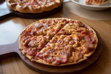 Pizza is delicious on the wooden table.
