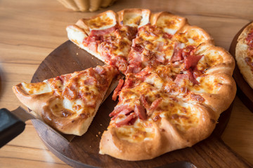 Pizza is delicious on the wooden table.