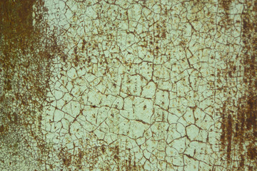 Rusty metallic surface covered with old cracked paint