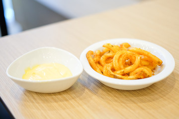 French fries with hot cheese dip sauce recipe serve on white plate for food background or texture - Fast Food concept.