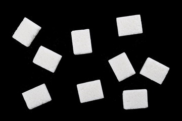 White sugar cubes isolated on black background and texture