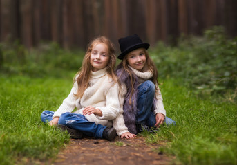 Fototapeta premium Two cute twins girls sisters walk 