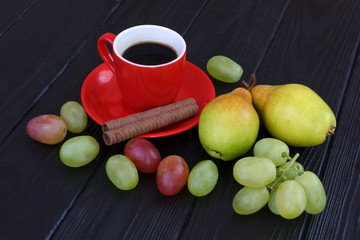 Autumn composition with coffee in red cup, sweet wafers, yellow pears and grapes