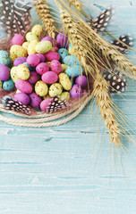 Easter colored eggs, feathers, blue wooden