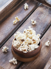Obraz na płótnie Canvas bowl of popcorn on a brown wooden table