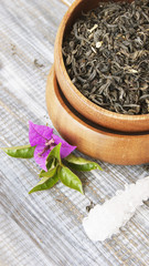 Green tea in a wooden bowl with flowers