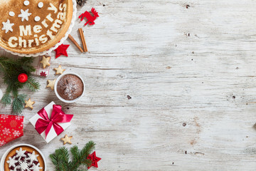 Merry christmas holiday decoration background. White wooden table. Space for text. Christmas cookies with gift box. Traditional homemade christmas cake decorated with snowflakes.